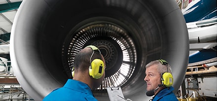 Engineers inspect aviation lubricants within an airplane engine