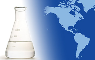 A laboratory flask with EHC 45/65 base stock on the foreground of a two-tone map of North and South America.