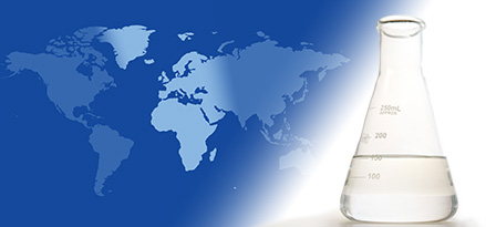 A laboratory flask with EHC 50/120 base stock on the foreground of a two-tone global map highlighting Europe, Africa, and the Middle East.