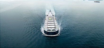 Front aerial view on container ship in the water