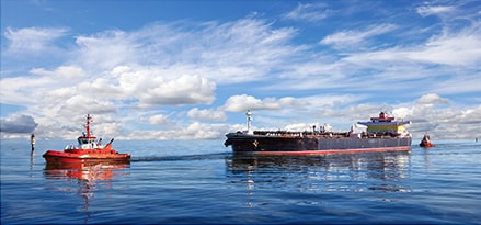 Tanker ship guided by tug boats